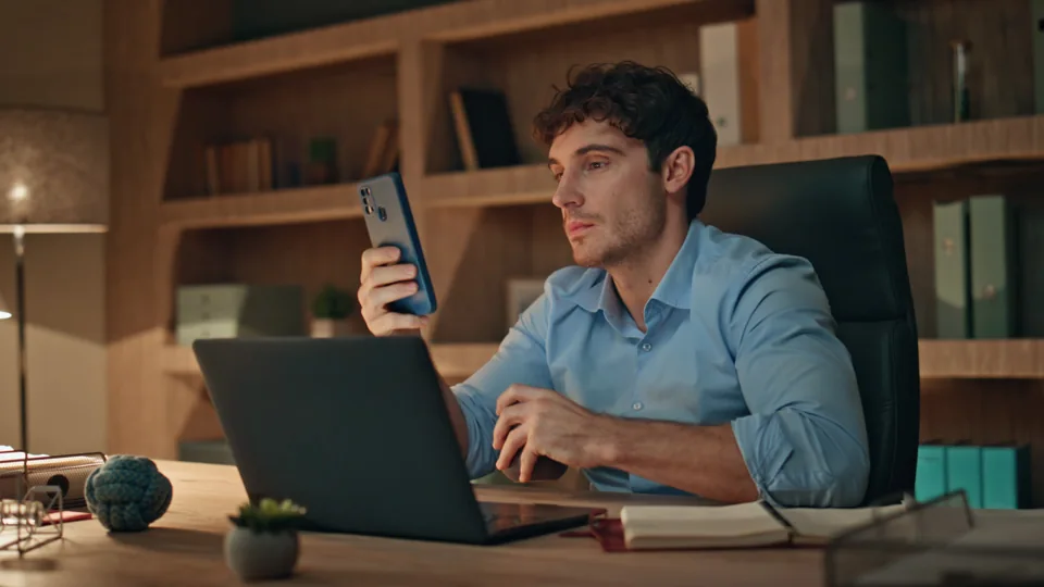 Pessoa utilizando celular no ambiente de trabalho